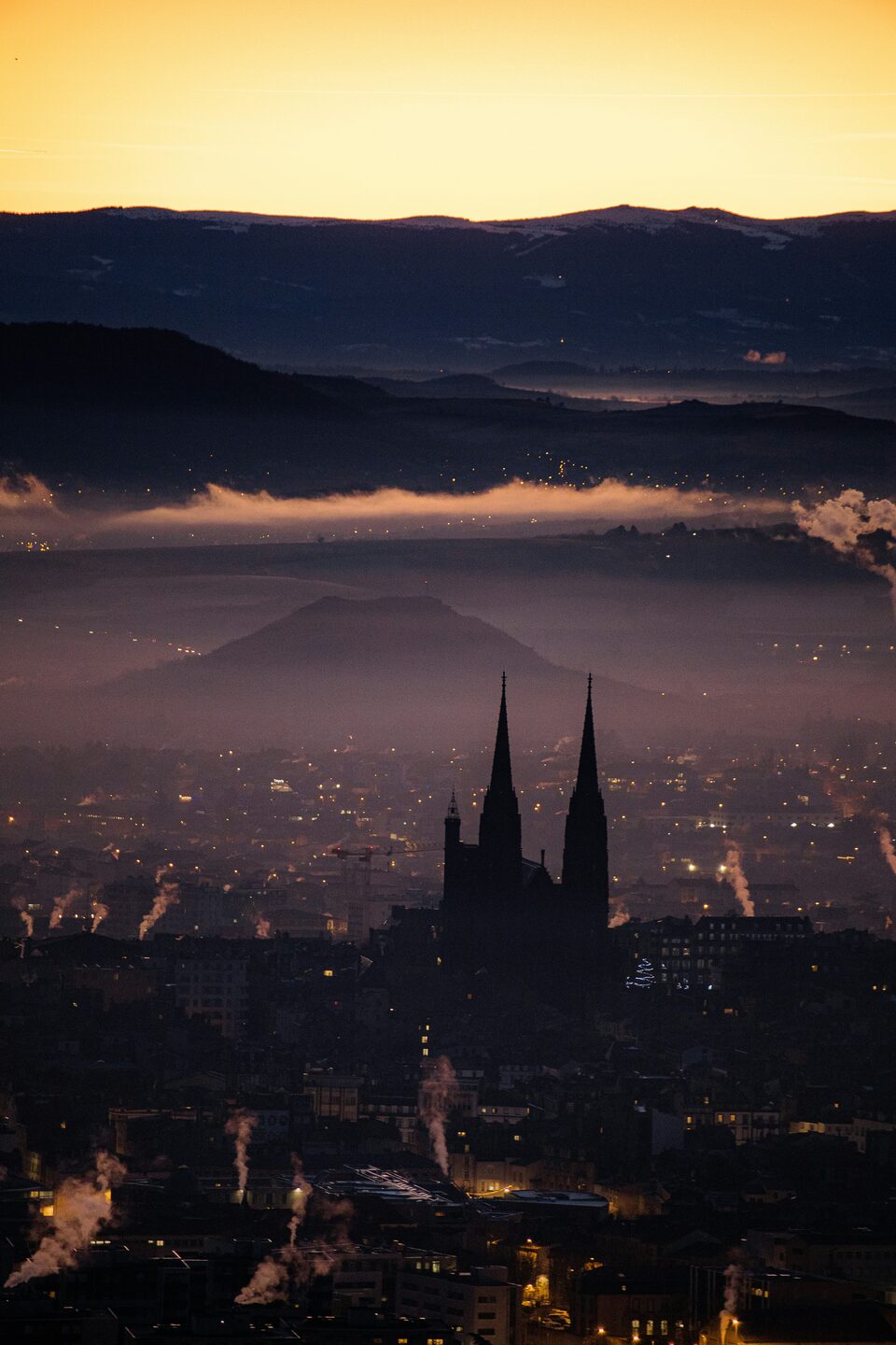 Cathédrale de Clermont-Ferrand au crépuscule, avec la silhouette du Puy de Dôme en arrière-plan